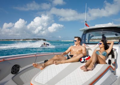 smiling couple sunbathing while sitting on the deck of the yacht