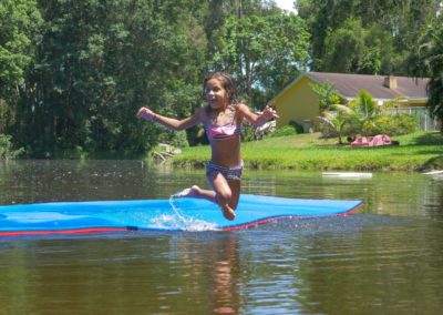 kid jumping on the water from the floating mat